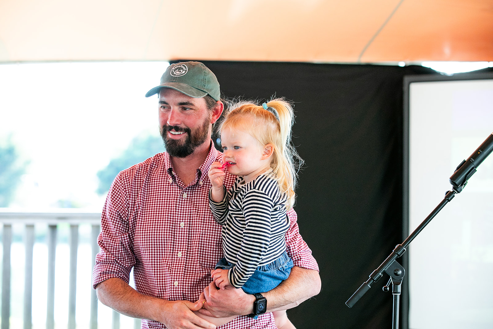 Will Dittmar holding his daughter at a community event